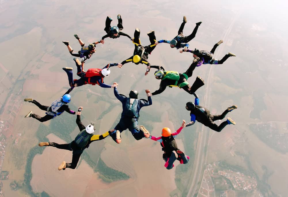 Skydivers,Holding,Hands,Making,A,Formation.,High,Angle,View.
