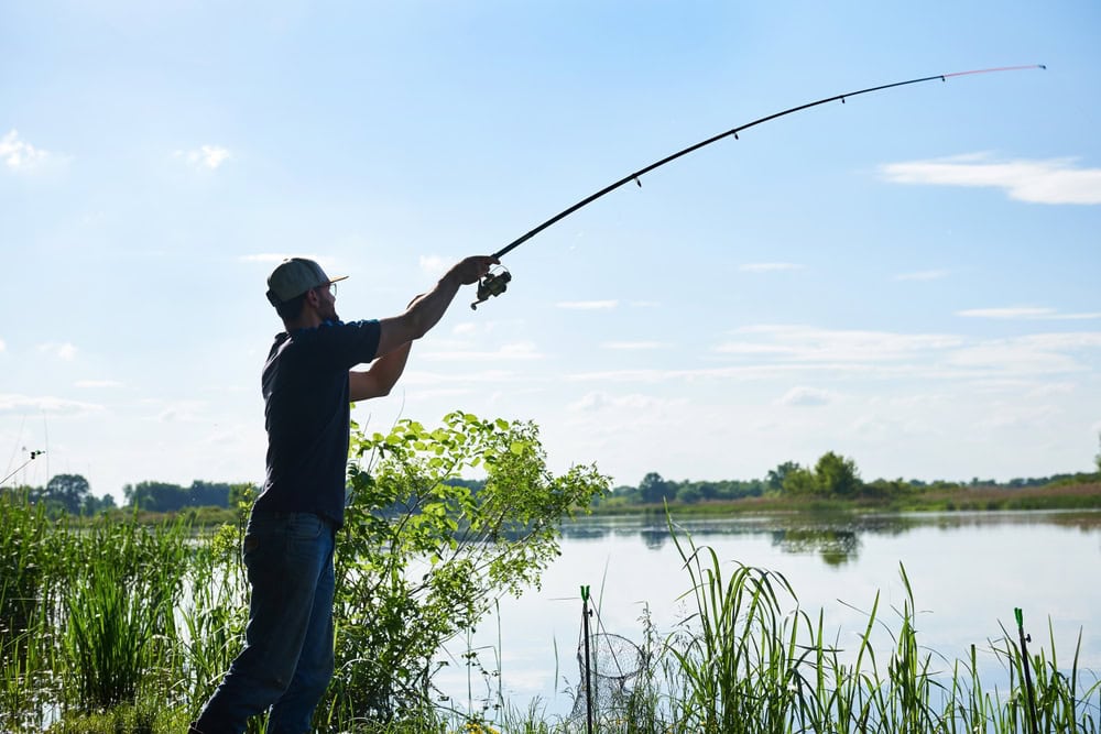 Silhouette,Of,Adult,Fisherman,Standing,By,The,River,And,Throwing